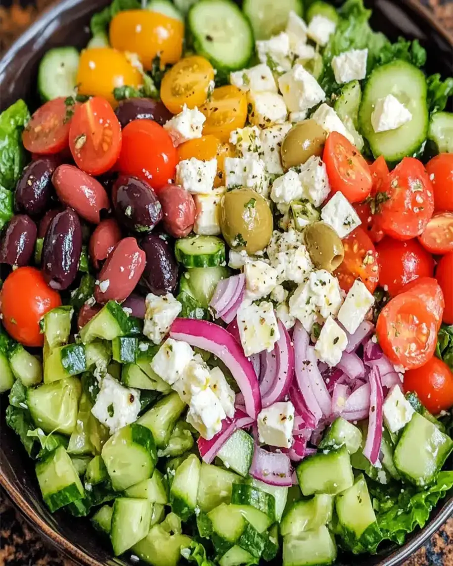 Finished Greek salad served on a plate with garnish, showcasing vibrant colors and freshness