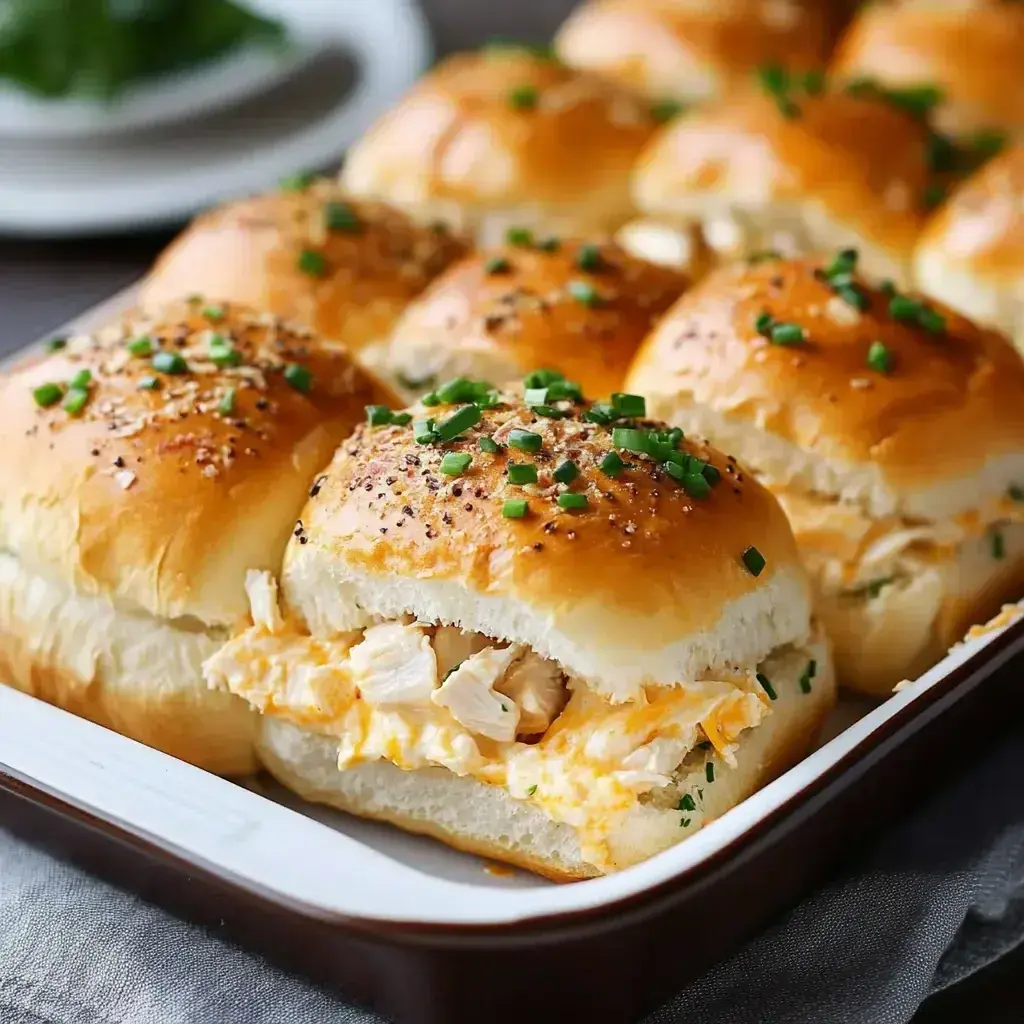 Close-up of a bite taken from a crack chicken slider, showing melted cheese and bacon.
