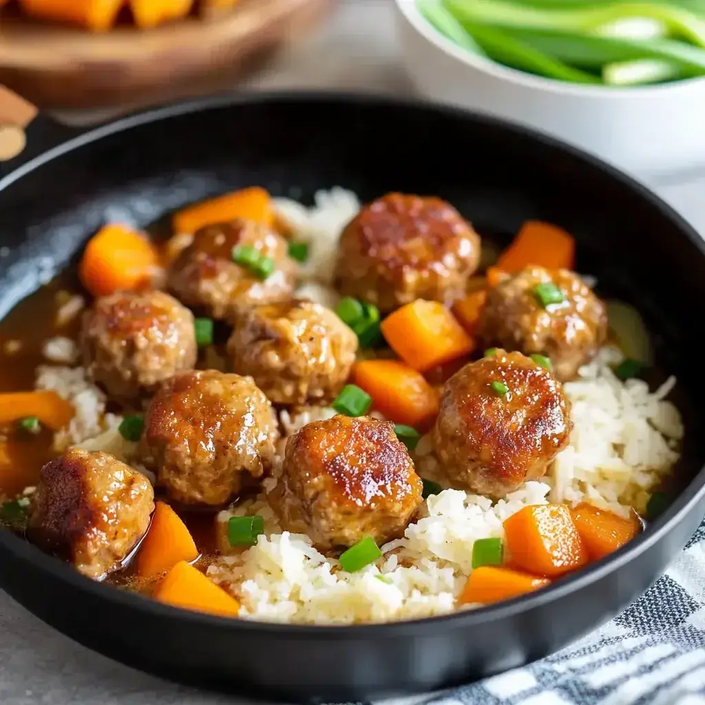 Finished adobo chicken meatballs served on a plate with rice
