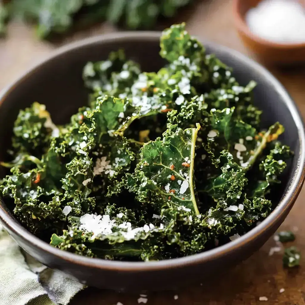 A bowl of freshly baked garlic parmesan kale chips, ready to enjoy as a healthy snack.